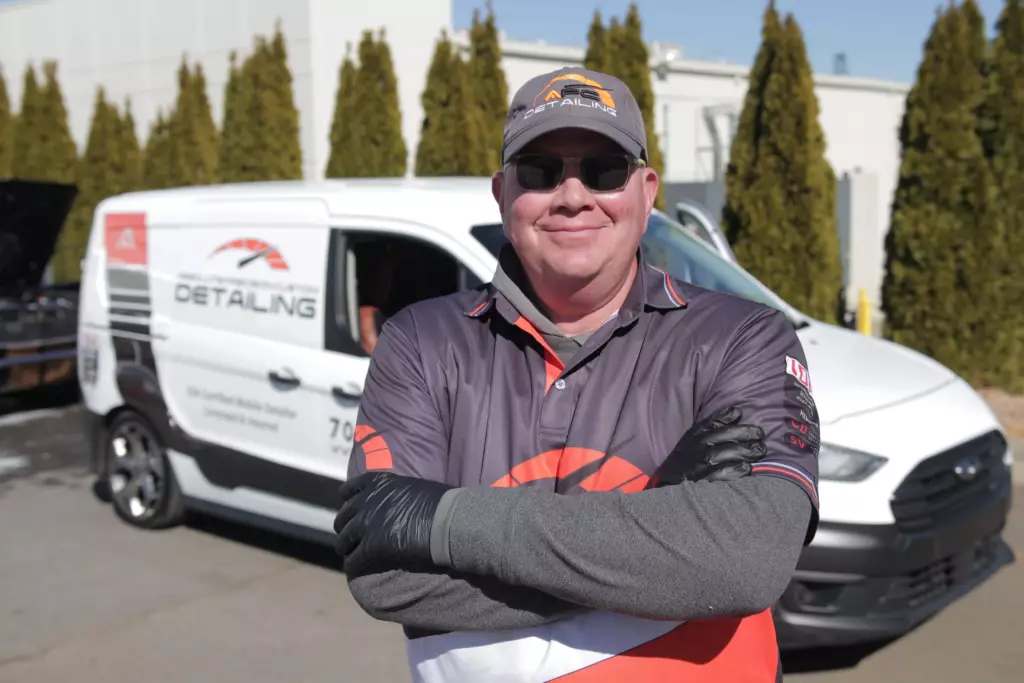 Technician from Absolute Precision Custom Detailing standing in front of a branded service van, showcasing professional mobile car detailing services.